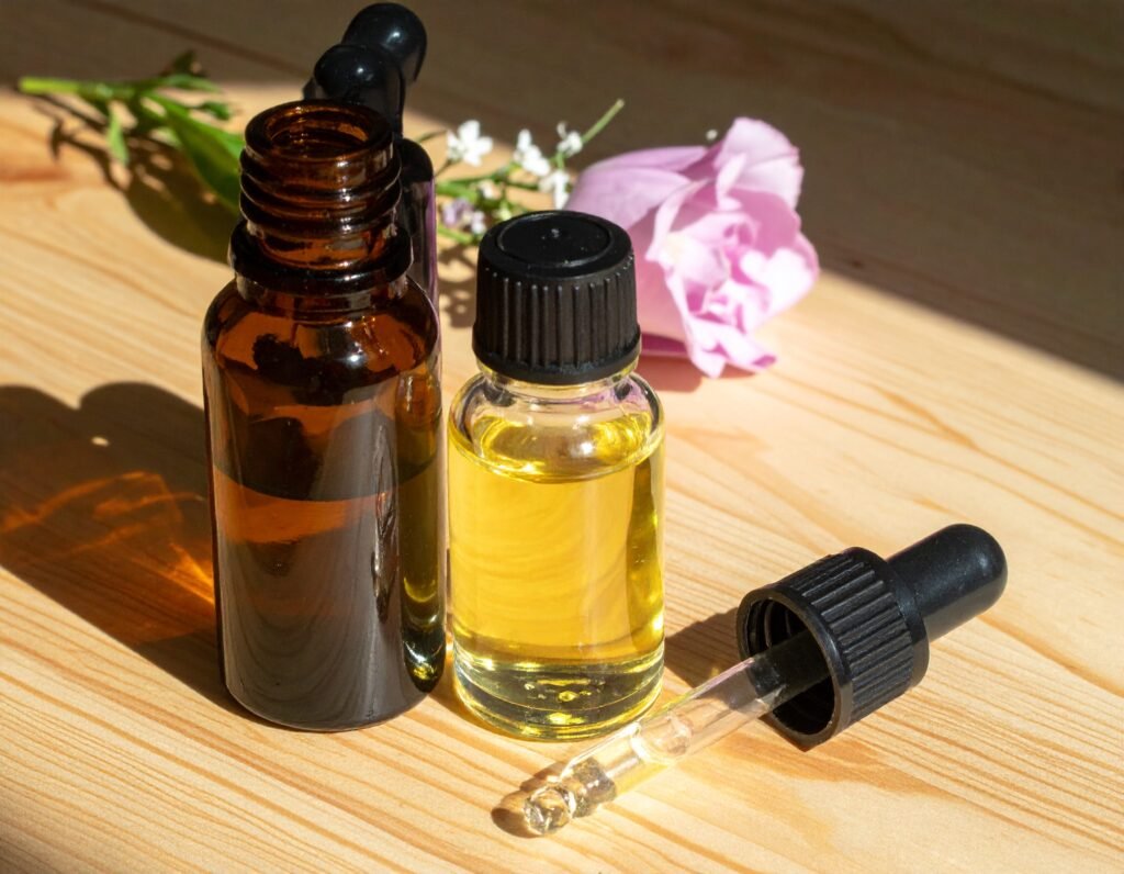 Apothecary-style essential oils and flowers in sunlight on a wooden table
