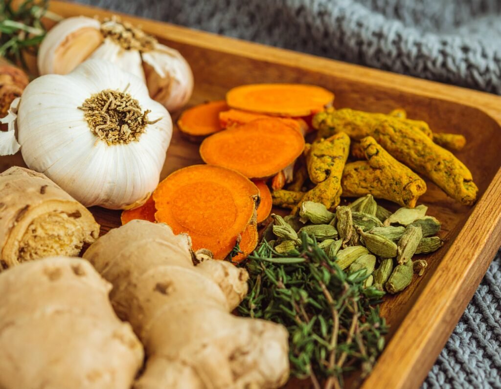 Close-up of sliced ginger, turmeric, astragalus sticks, burdock, and garlic