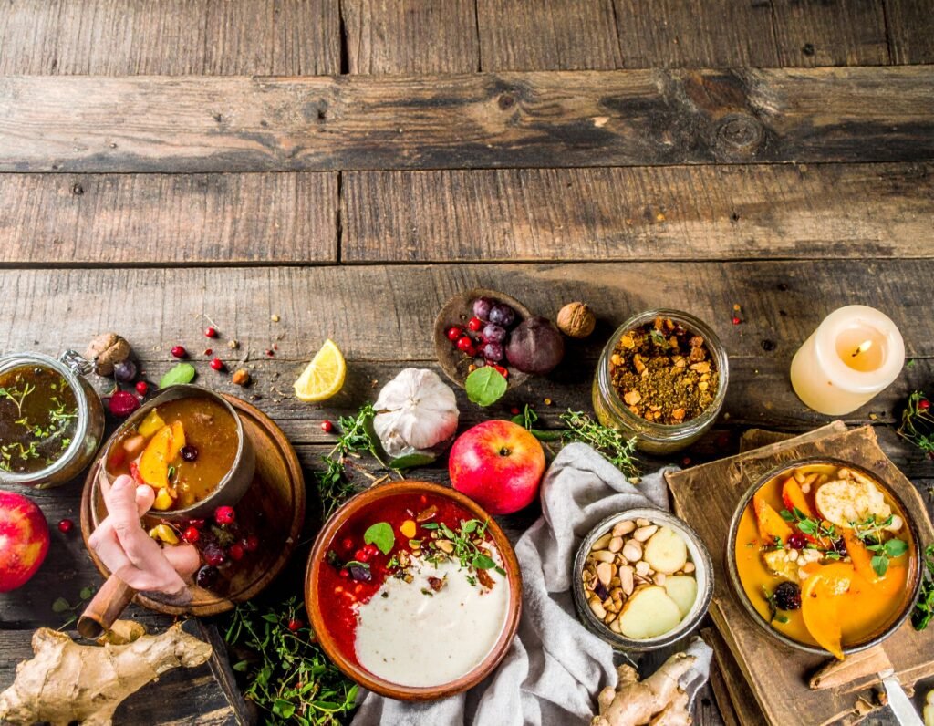 Mugs of herbal root tea, pot of root soup, jar of honey-ginger syrup