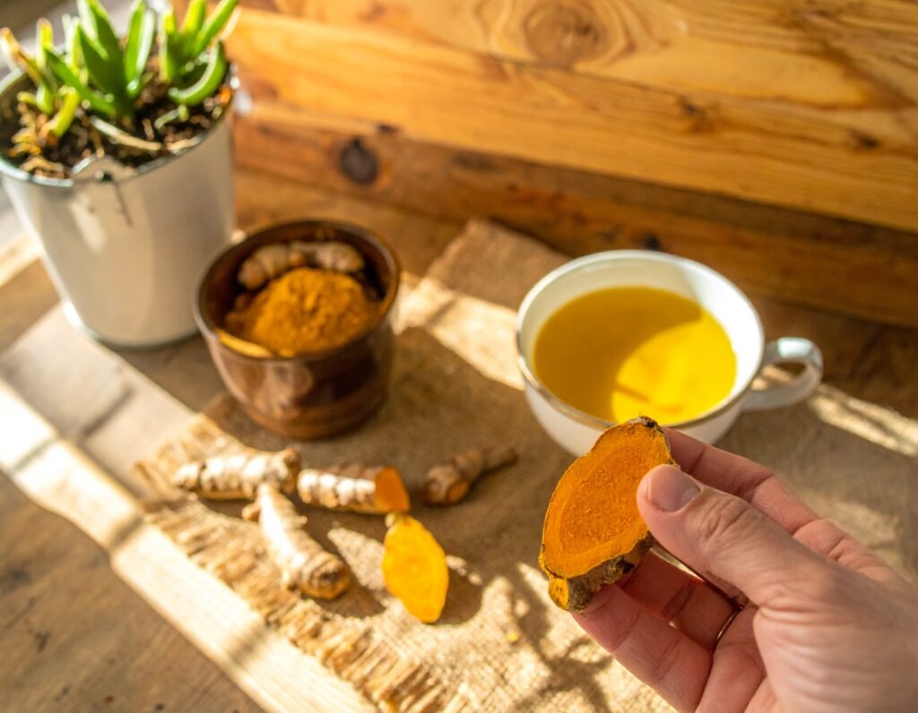 Sunlit kitchen table with turmeric roots and plant