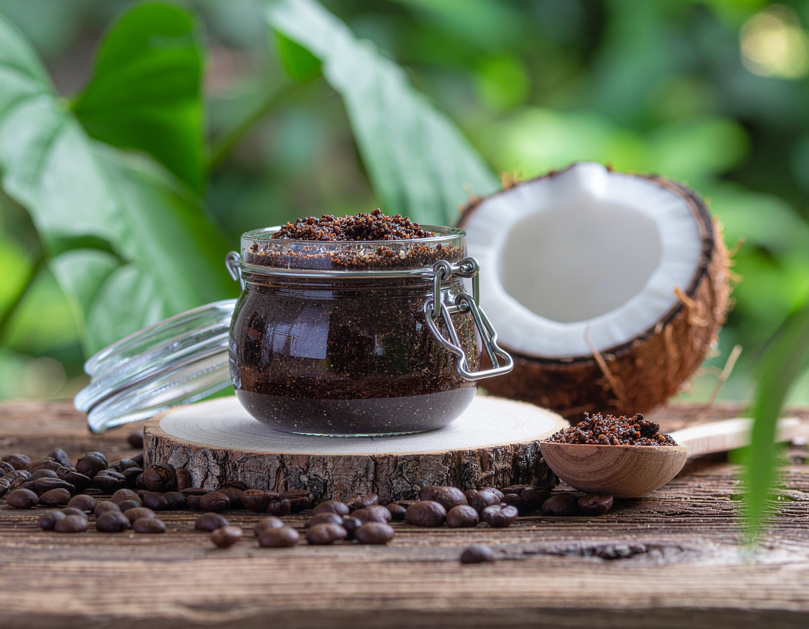 Homemade coffee scrub beside coconut oil and spoon